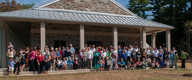 Photo of the Chestnut Hill Friends meetinghouse, with about 50 people gathered on the steps.