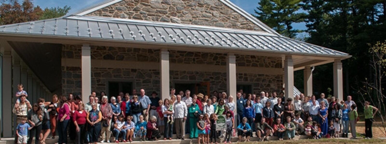 Photo of the Chestnut Hill Friends meetinghouse, with about 50 people gathered on the steps.